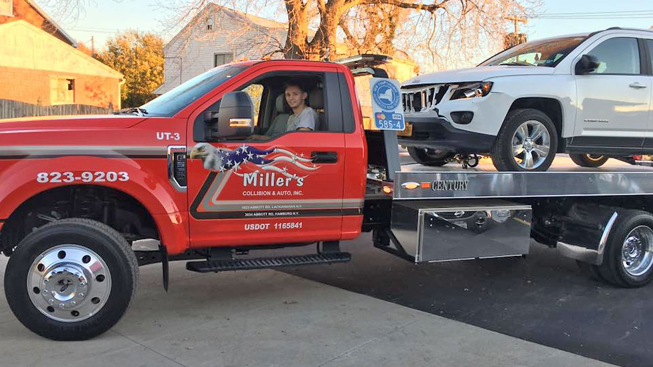 man in wrecker hauling a damaged SUV